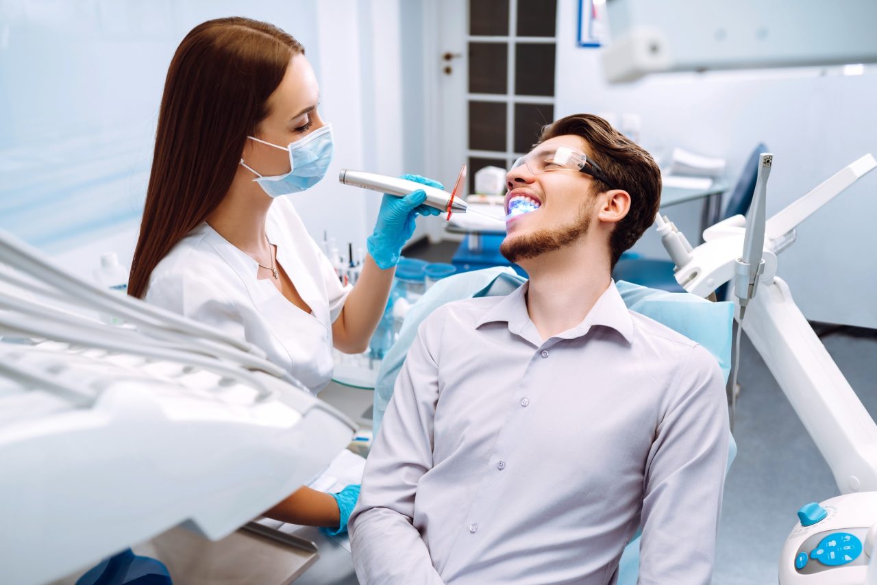 young man at the dentist s chair during a dental procedure overview of dental caries prevention